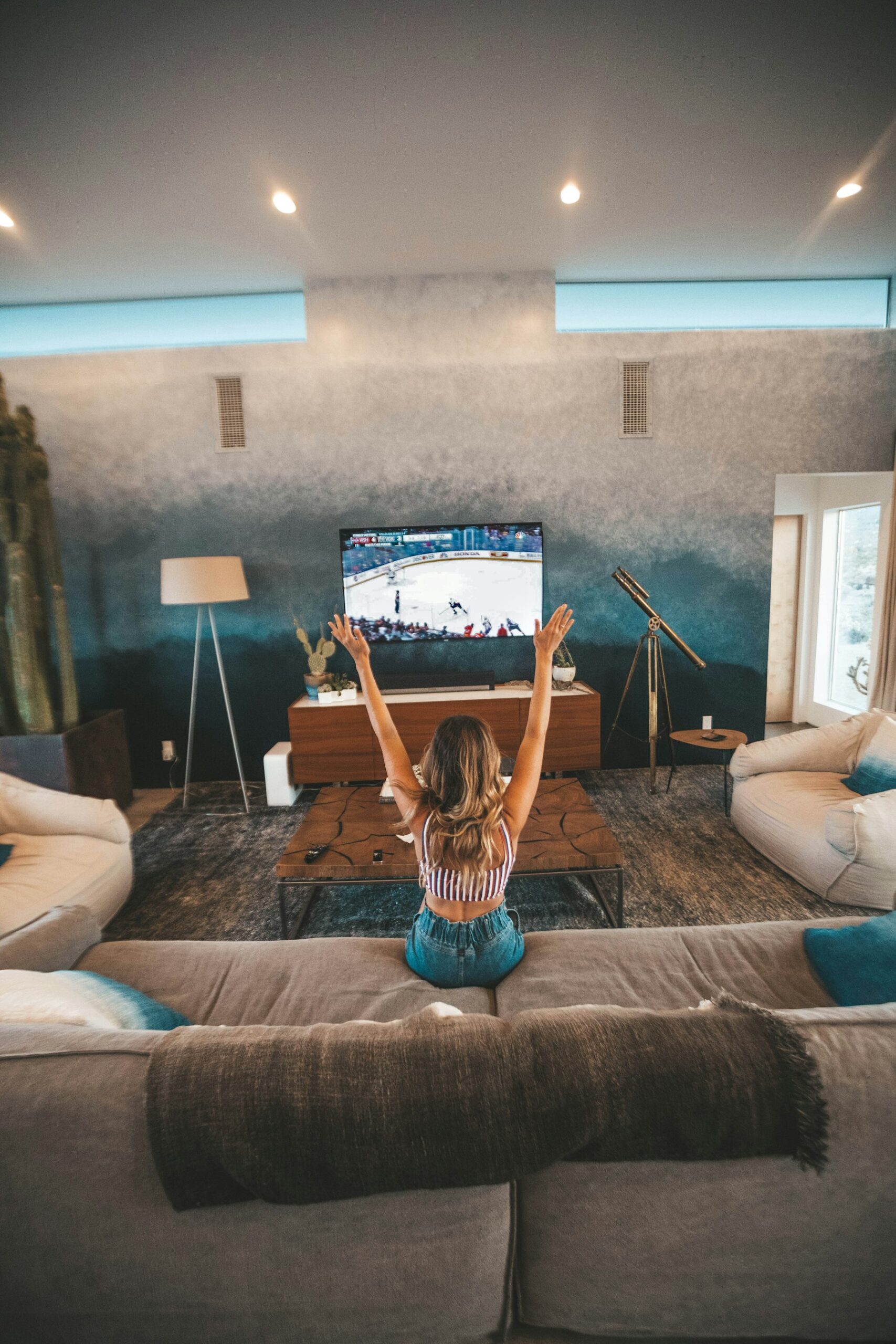 A viewer watching sport on a large television